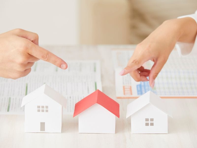 mano indica modellini di case a simbolo degli investimenti immobiliari