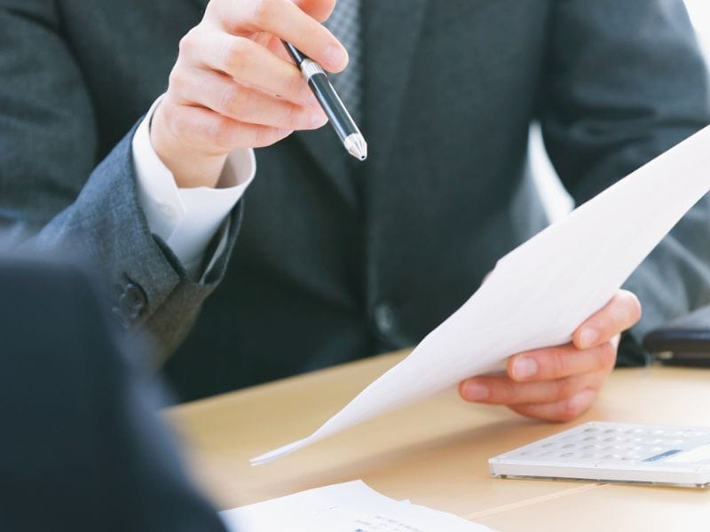 uomo con penna e documento da firmare