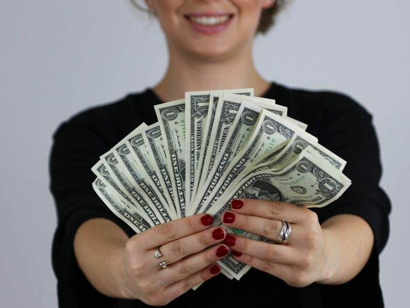 influencer con dollari a indicare di stare attenti ai consulenti finanziari improvvisati su internet